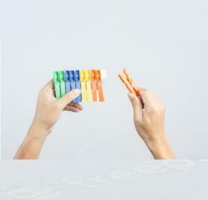 hand-holding-row-colorful-plastic-cloth-clamp-clip_33745-601